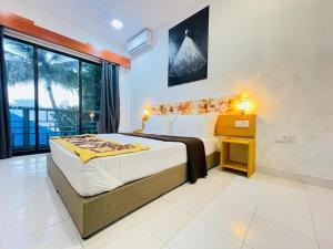 een slaapkamer met een groot bed en een raam bij Paradise Retreat, Maafushi in Maafushi
