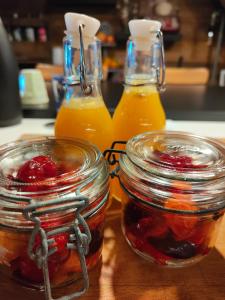 zwei Gläser Honig und zwei Flaschen Orangensaft in der Unterkunft Le mazot d'H in Entremont