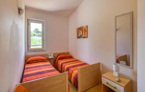 two beds in a small room with a mirror at Villa Maria Carmela in Briatico