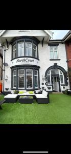 a building with benches in the grass in front of it at North Crest in Blackpool