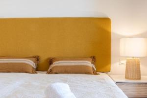 1 dormitorio con 1 cama grande y cabecero amarillo en CT 199 - Duquesa Village, en Manilva