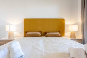 1 dormitorio con 1 cama blanca grande y 2 lámparas en CT 199 - Duquesa Village, en Manilva