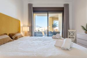 a bedroom with a large white bed with towels on it at CT 199 - Duquesa Village in Manilva