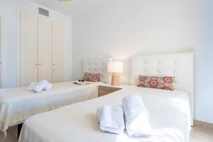 two beds in a bedroom with white walls at CT 199 - Duquesa Village in Manilva +29 photos