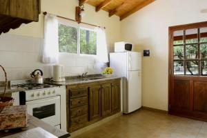 a kitchen with a white refrigerator and a sink at Dorado del Sol in Merlo