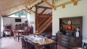 a dining room with a table and chairs and a staircase at Șura lu' Vasile. in Crivina