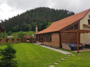 una cabaña de madera con un patio al lado de una casa en Șura lu' Vasile., en Crivina