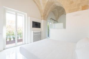 マテーラにあるVittorio Veneto Matera Luxury Roomsの白いベッドルーム(ベッド1台、窓付)