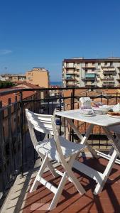 a white table and a chair on a balcony at Il Nido di Pikki in Falconara Marittima