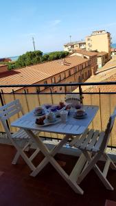 a table with plates of food on a balcony at Il Nido di Pikki in Falconara Marittima