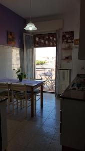 a kitchen with a table and a view of a balcony at Il Nido di Pikki in Falconara Marittima