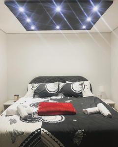 a bedroom with a black and white bed with lights at Checkmate in Tešanj