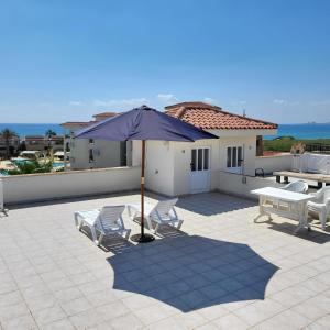 a patio with chairs and an umbrella on a roof at SUMMER TERRACE 26 in Kalecik