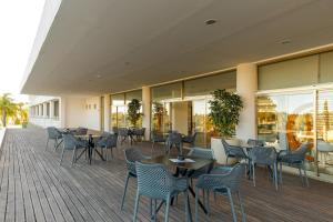 um restaurante com mesas, cadeiras e janelas em Pelican Alvor em Alvor