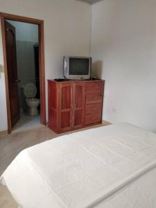 Schlafzimmer mit einem TV auf der Kommode in der Unterkunft Hermoso apartamento in La Dorada