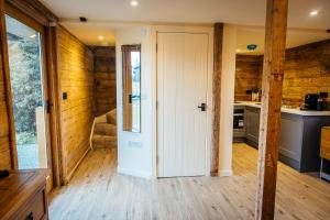 a kitchen with wooden walls and a white door at The Granary in Canterbury