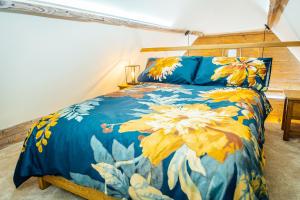 een slaapkamer met een bed met een blauwe en gele sprei bij The Granary in Canterbury