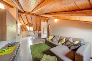 un soggiorno con divano grigio e tappeto verde di Mansarda fra monte e lago a Esino Lario