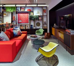 a living room with a red couch and a yellow chair at citizenM Paris Opera in Paris