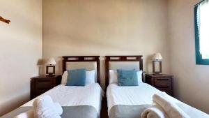 un dormitorio con dos camas y dos sillas en La Maison dAndres, by Comfortable Luxury, en La Oliva