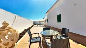 a patio with chairs and a glass table on a balcony at La Maison dAndres, by Comfortable Luxury in La Oliva