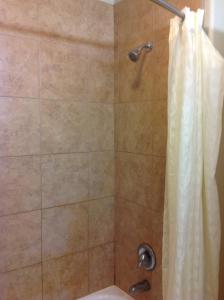 a bathroom with a shower with a shower curtain at Yorktown Inn and Suites in Yorktown