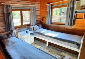 a room with two beds in a log cabin at Kleiner Bungalow Am Wald in Petershagen