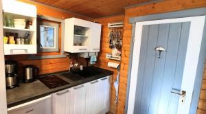 a kitchen with white cabinets and a sink at Kleiner Bungalow Am Wald in Petershagen