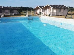 a large swimming pool with blue water at Rio Park domki letniskowe Łukęcin in Łukęcin