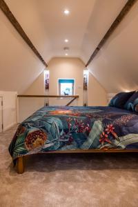 1 dormitorio con 1 cama grande con una manta colorida en The Stable, en Canterbury