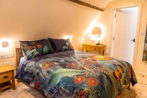a bedroom with a bed with a colorful comforter at The Stable in Canterbury