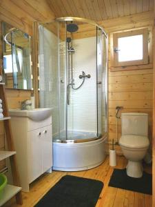 a bathroom with a shower and a toilet and a sink at Rio Park domki letniskowe Łukęcin in Łukęcin +17 photos