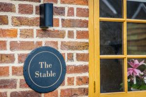 a sign on the side of a brick building at The Stable in Canterbury