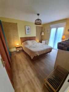 a bedroom with a bed in a room with wooden floors at La Maison d'Estrella in Moussoulens