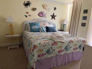 a bedroom with a bed with a comforter on it at Miramar Condominiums in Ocean City