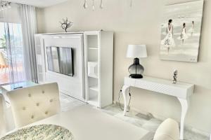 Sitio de CalahondaにあるMI CAPRICHO BEACHFRONT- 9F Apartment with sea views - Costa del Solの白いリビングルーム(白いテーブル、椅子付)