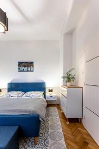 a bedroom with a blue bed and a white cabinet at Mojmirova Apartment Kosice Center in Košice