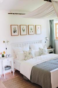 1 dormitorio con cama blanca y sofá blanco en Ferienwohnung Bergliebe Höhenmoos, en Rohrdorf