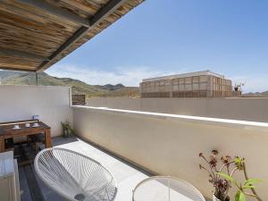 a balcony with chairs and a table and a building at Casa Ailanto in El Pozo de los Frailes