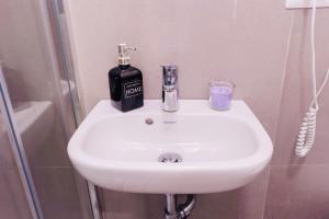 a bathroom sink with a bottle of soap on it at Daniel's Apartment in Bari +16 photos