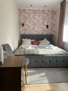 a bedroom with a bed with a gray couch at Apartament Mickiewicza in Busko-Zdrój