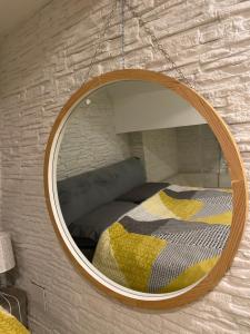 a mirror hanging on a wall with a bed at Home Porta Di Castro in Palermo