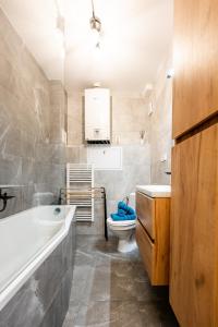 a bathroom with a tub and a toilet and a sink at Mojmirova Apartment Kosice Center in Košice
