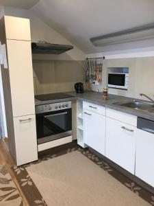 - une cuisine avec des placards blancs et une cuisinière dans l'établissement Ferienwohnung in Wiesent-gerne Handwerker/Monteure, à Wiesent