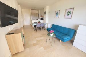 - un salon avec un canapé bleu et une table dans l'établissement Apartamento SOLSILK, à Torremolinos