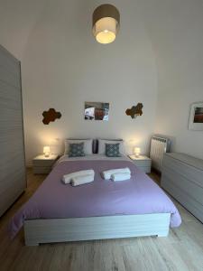 una camera con un grande letto viola con due lampade di Corte Aragonese a Piano di Sorrento