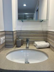 un lavandino in bagno con asciugamano e specchio di Corte Aragonese a Piano di Sorrento