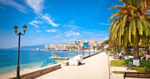a sidewalk next to the ocean with palm trees at UN BEL POSTO AL MARE in Savona