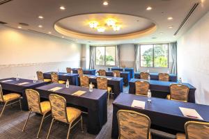 een conferentiezaal met blauwe tafels en stoelen bij ANA Holiday Inn Resort Miyazaki, an IHG Hotel in Miyazaki