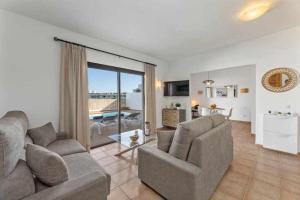 a living room with two couches and a living room with a view at Villa RamiMedi 4 in Tías
